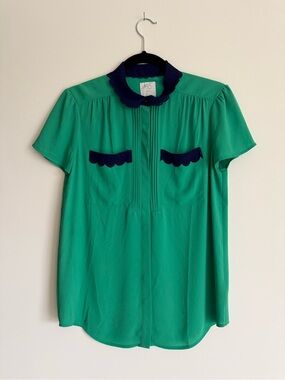 Anthropologie green blouse with navy laser-cut trim, pristine condition